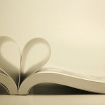 Opened book with heart page against blank background.
